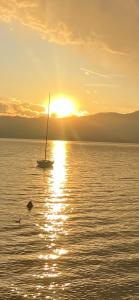 łódź żaglowa w wodzie o zachodzie słońca w obiekcie Casa Cavour w mieście Garda