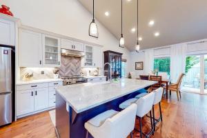 a kitchen with a large island with white cabinets at North End Farmhouse in Boise