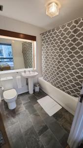 La salle de bains est pourvue d'une baignoire, de toilettes et d'un lavabo. dans l'établissement Top Floor Room in Baker St, à Londres