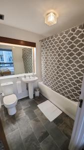 uma casa de banho com uma banheira, um WC e um lavatório. em Top Floor Room in Baker St em Londres