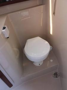 a bathroom with a white toilet in a room at Virginia Bed and Boat in Siracusa