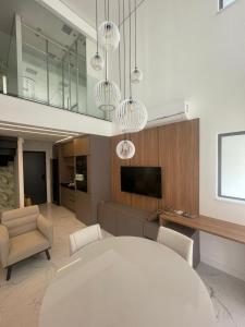 a living room with a white table and a tv at Apartamento de luxo em Jardins, Oscar Freire in Sao Paulo