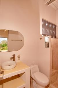 bagno bianco con servizi igienici e lavandino di ILUKA VILLAS a Coveñas