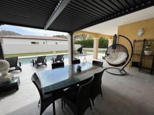 a patio with a table and chairs and a swing at Villa Provençal in La Roque-dʼAnthéron