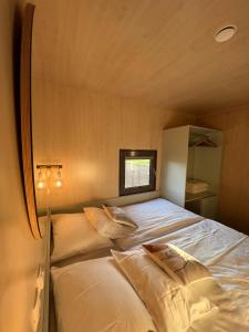 una camera con un letto in una piccola stanza di MAGNOLIA HOUSE by the RIVER XL a Metlika
