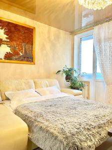 um quarto com uma cama grande e um sofá em Zoryaniy Apartments City ПРОСТОРА та затишна НОВОБУДОВА біля парку Шевченка та ЦЕНТРУ em Chernivtsi