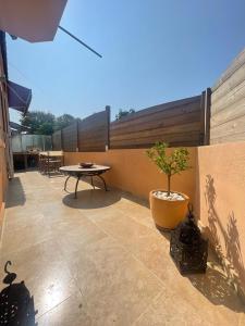a patio with a table and a potted plant at Floramarine in Saint-Raphaël