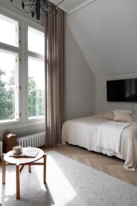 a white bedroom with a bed and a coffee table at Villa Ryselin in Tampere