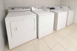 a laundry room with white washers and dryers at Courtyard Monterrey Airport in Monterrey