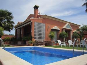 a house with a swimming pool in front of a house at Chalet Martin in Chiclana de la Frontera