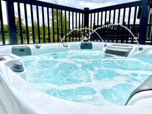 a jacuzzi tub in a deck with a fence at Ella Lodge in Lincoln