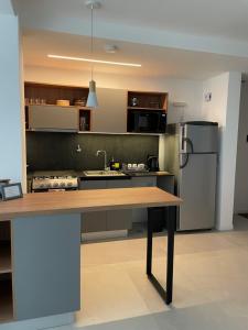 a kitchen with a wooden table and a refrigerator at Departamento Rosas in Ushuaia