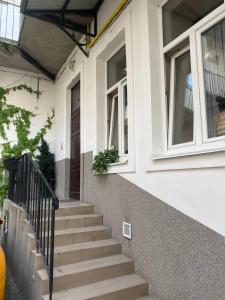 a white house with stairs and a window at Budget Family Hotel in Lviv