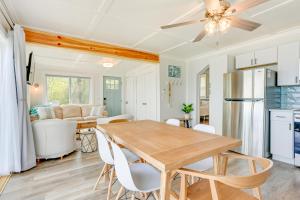 eine Küche und ein Esszimmer mit einem Holztisch und Stühlen in der Unterkunft Beachy Palms Cottage on Lake Huron with Hot Tub! in Palms