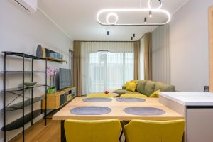 - un salon avec une table et des chaises jaunes dans l'établissement Bremeni Apartment Pärnu jõe kaldal, à Pärnu