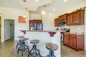 a kitchen with wooden cabinets and bar stools at Mesquite Vacation Rental - Close to Golf Courses! in Mesquite