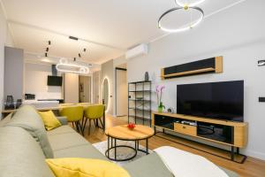 Il comprend un salon doté d'un canapé et d'une télévision à écran plat. dans l'établissement Bremeni Apartment Pärnu jõe kaldal, à Pärnu