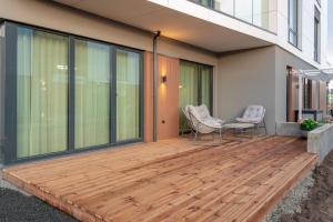 - une terrasse en bois sur le côté d'une maison dans l'établissement Bremeni Apartment Pärnu jõe kaldal, à Pärnu