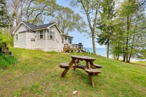 einem Picknicktisch vor einem Haus in der Unterkunft Beachy Palms Cottage on Lake Huron with Hot Tub! in Palms