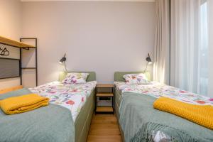 - 2 lits jumeaux dans une chambre avec fenêtre dans l'établissement Bremeni Apartment Pärnu jõe kaldal, à Pärnu