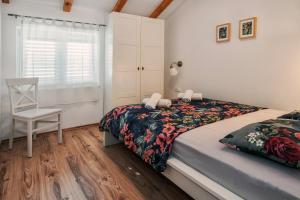 ein Schlafzimmer mit einem Bett, einem Stuhl und einem Fenster in der Unterkunft Sunny Apartments in Stobreč