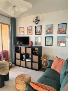 ein Wohnzimmer mit einem grünen Sofa und einem TV in der Unterkunft Super appartement vue Sanguinaires in Ajaccio