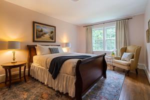 a bedroom with a bed and a chair and a window at Luxury Farmhouse in the Heart of Historic Downtown in Cartersville