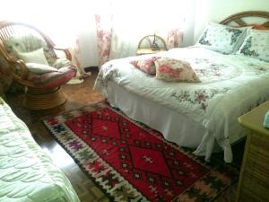 a bedroom with a bed and a rug and a chair at B&B Pane & Tulipani in Duino