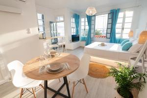 a living room with a table and chairs and a couch at The White Rose Apartment in Poros