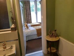 Baño con habitación con cama y lavabo en Holywell House, en Loughborough