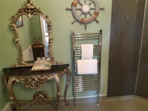 a bathroom with a mirror and a table with towels at Holywell House in Loughborough