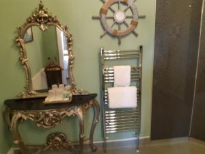 a bathroom with a mirror and a table with a sink at Holywell House in Loughborough