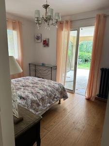 a bedroom with a bed and a table and a window at L'Eden de l'Esterel in LʼÉglise