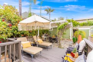 a deck with chairs and an umbrella at Hues and Views in Laguna Beach