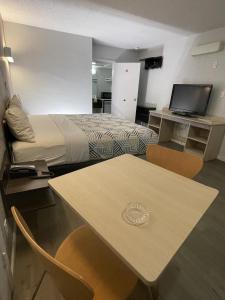 a hotel room with a bed and a table with chairs at Motel 6-Sallisaw, OK in Sallisaw