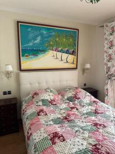 a bedroom with a bed and a picture of a beach at L'Eden de l'Esterel in LʼÉglise