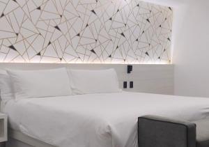 a bedroom with a white bed with a wall at La Casona Que Encanta antes The Andy Hotel in Querétaro +80 photos