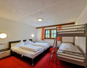 two beds in a room with two bunk beds at Ferienhaus Alpenschlössl in Lermoos