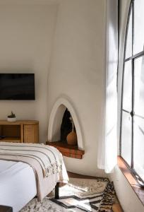 a white bedroom with a bed and a fireplace at Casa Blanca Suite B2 - New, Private, Cozy! in Montecito