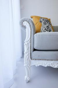 una sedia bianca in una stanza bianca con tende di Mosaic Cosy House a Chio (Chios)