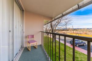 een stoel op een balkon met uitzicht op een straat bij Ramada by Wyndham Grand Junction in Grand Junction