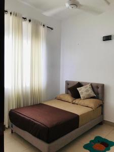 ein Bett in einem Schlafzimmer mit einem Fenster in der Unterkunft Furnished homelike apartment at Mount Clifford Range,Homagama in Homagama