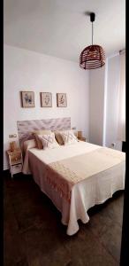 a bedroom with a large bed with a white blanket at La Casita del Arroyo in Arroyo Frio