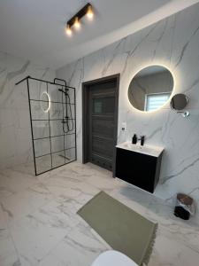een badkamer met een wastafel en een spiegel bij Kierunek Górki 