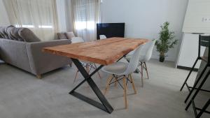 - une table et des chaises en bois dans le salon dans l'établissement Ona Beach daimuz, à Daimús