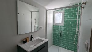 Un baño con lavabo y ducha de cristal. en Ona Beach daimuz, en Daimuz