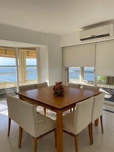 a dining room with a wooden table and white chairs at Bitcoins House Costanera in Corrientes