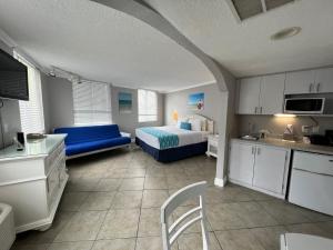 クリアウォーター・ビーチにあるPelican Pointe Hotelのベッドルーム1室(ベッド1台、青いソファ付)