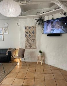 sala de estar con TV de pantalla plana en la pared en Nomad Cave en Estocolmo