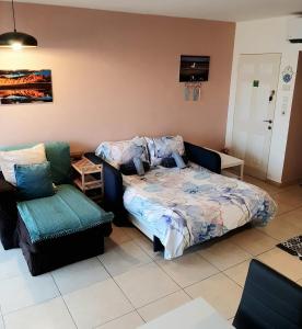 een slaapkamer met een bed en een stoel bij Bluestone Vacations in Lev Eilat in Eilat